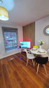 ein Wohnzimmer mit Tisch und Stühlen und einem Fernseher in der Unterkunft Cozy 1 bedroom apartment, Sheffield city center, free wifi in Sheffield + 21 Fotos