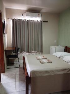 a bedroom with a bed with two towels on it at Hotel Roma Valparaíso de Goiás in Valparaíso de Goiás +9 photos