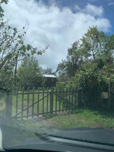 a wooden fence with a house behind it at Les Châlets du Medinilla in La Plaine des Palmistes