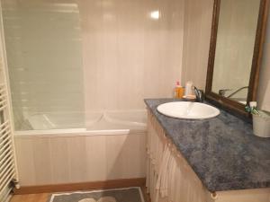 a bathroom with a sink and a bath tub at Les volets bleus in Les Angles