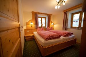 une chambre avec un lit avec des oreillers rouges dessus dans l'établissement Ferienwohnung Triembachhof, à Schönau am Königssee