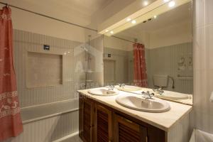 Un baño con dos lavabos y un espejo grande. en Solazur by ACasaDasCasas, en Ericeira 11 fotos más
