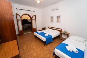 Una habitación de hotel con dos camas y un pasillo. en {beach-house } Villa Mare Fuori, en Mazara del Vallo