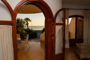 una puerta abierta a una habitación con vistas al océano en {beach-house } Villa Mare Fuori, en Mazara del Vallo