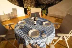 una mesa con platos y una botella de vino. en {beach-house } Villa Mare Fuori, en Mazara del Vallo