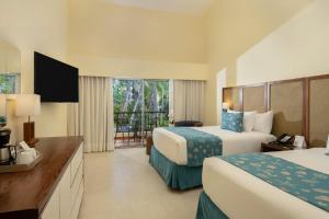 a hotel room with two beds and a balcony at Impressive Punta Cana - All Inclusive in Punta Cana
