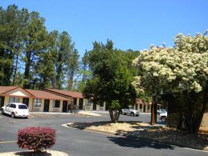 a parking lot in front of a building with flowering trees at SleepWell Stockbridge in Stockbridge