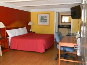 a hotel room with a bed and a desk and a computer at SleepWell Stockbridge in Stockbridge