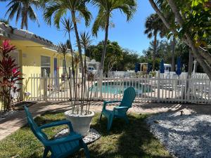 a yard with two chairs and a swimming pool at Bahama Beach Club Pompano - Fort Lauderdale - Charming and Cozy Studios & Apartments close to Beach with Pool in Pompano Beach