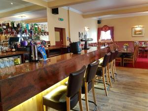 un bar con una fila de sillas alrededor en The Panmure Arms Hotel, en Edzell