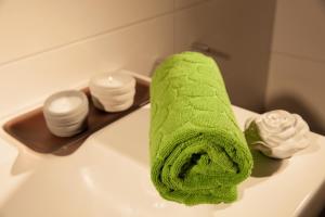 a green towel sitting on top of a bathroom sink at Tischneck Chalets - TraumFerienhäuser im Schwarzwald - Chalets Riva & Limone in Hardt +60 photos