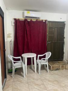 Una mesa y dos sillas en una habitación con una cortina roja. en Sophia House, en Cartagena de Indias