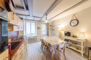 カンカルにあるCharmante maison pêcheur - 50m merのテーブルと壁に時計があるキッチン +1枚の写真
