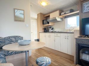 a kitchen and a table in a small room at Chalet 588 op Recreatiepark De Wielen in Sint Maarten