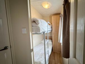 a small room with two bunk beds in it at Chalet 588 op Recreatiepark De Wielen in Sint Maarten +23 photos
