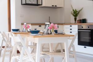 a kitchen with a wooden table and white chairs at Ponte Nuovo BB in Verona +32 photos