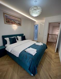 a bedroom with a large bed with towels on it at Family Nest in Vărbilău