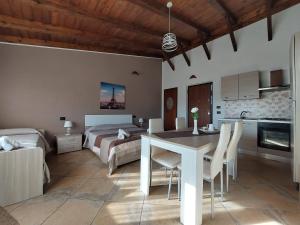 a kitchen and living room with a table and a bed at B&B la Sirenetta in Diamante