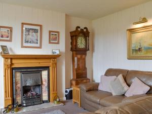 een woonkamer met een bank en een grootvaderklok bij Thurston View in Coniston