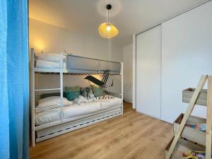 a bedroom with two bunk beds and a staircase at Les Ganivelles - Belle maison neuve avec extérieur in La Tremblade