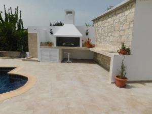 a patio with a fireplace and a kitchen with a sink at Antigoni's Cottage in Choulou