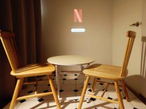 two wooden chairs and a table with a letter k on the wall at 상왕십리역3분#미니영화관#층전체#동대문#명동#홍대#종로#성수#서울숲#한양대#청계천#공항버스 in Seoul
