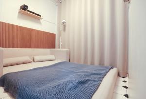 a bedroom with a bed with a blue blanket on it at 상왕십리역3분#미니영화관#층전체#동대문#명동#홍대#종로#성수#서울숲#한양대#청계천#공항버스 in Seoul