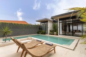 DalungにあるStunning 3-Bedroom Luxury Villa with Private Pool, Netflix, and Amazing Views!の椅子2脚と家のあるプール