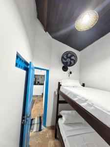a room with two bunk beds and a blue door at Dunas House in Luis Correia