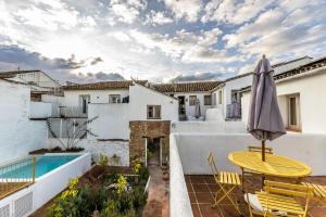 a patio with a table and chairs and an umbrella at Romantic Ronda garden cottage in Ronda