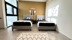 a bedroom with two beds and a rug at Tu Villa Adosada Lujo con Playa y Golf in Akumal +8 photos