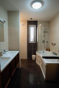 a bathroom with two sinks and a tub and a toilet at MD Stays in Portstewart +64 photos