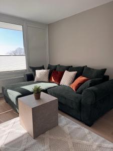 a living room with a green couch and a table at Fewo Strandbrise in Eckernförde