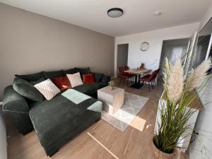 a living room with a black couch and a table at Fewo Strandbrise in Eckernförde +9 photos