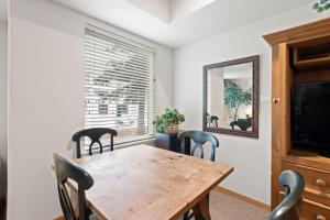 a dining room with a table and chairs and a mirror at Palisades Tahoe Lodge Rentals Studio #111 in Olympic Valley