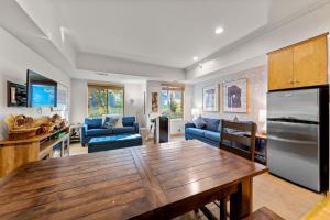 a kitchen and living room with a wooden table at Palisades Tahoe Lodge Rentals Studio #110 in Olympic Valley