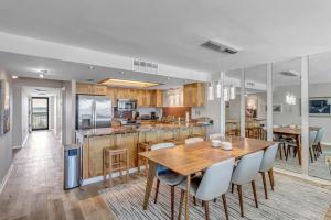 a kitchen and dining room with a wooden table and chairs at Crescent Surf in Cedar Landing
