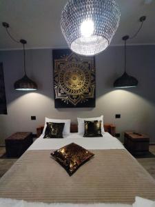 a bedroom with a large bed with a large chandelier at La Signoria Relais in Ferrara