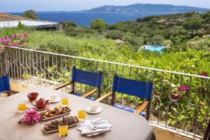 a table with plates of food on top of a balcony at Residence Il Mirto in Palau