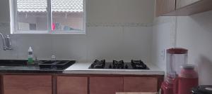 a kitchen with a stove and a sink and a window at Casa ideal 5 quatros sendo 3 suítes 2 km do centro in Bananeiras