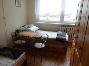 ヴロツワフにあるApartament Widokowyのテーブルと椅子、窓が備わる小さな客室です。