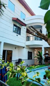 a woman standing in front of a house at Villa Saint-Sulpice Apt avec piscine in Yaoundé +5 photos