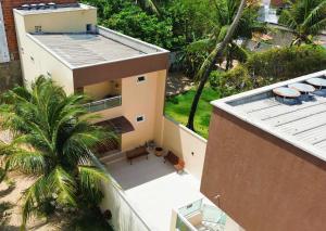 an aerial view of a house with a palm tree at Bella Spiaggia Suítes Centro de Flecheiras, perto da praia in Flecheiras +21 photos