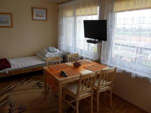 a room with a table and a bed and a television at Apartament Widokowy in Wrocław