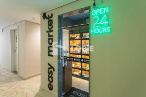 an open hours sign in front of a refrigerator at Lobie Gloria Del'Art in Rio de Janeiro