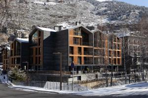 a black building on a street with a mountain at Isard Homes by Select Rentals in El Tarter