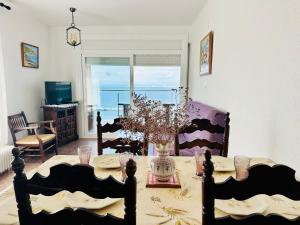 ein Wohnzimmer mit einem Tisch und einer Blumenvase in der Unterkunft Global Immo 3017 Monaco in Roses