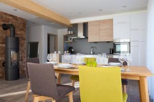a kitchen and dining room with a wooden table and chairs at Tischneck Chalets - TraumFerienhäuser im Schwarzwald - Chalets Riva & Limone in Hardt