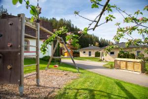 a playground in a yard with a swing at Tischneck Chalets - TraumFerienhäuser im Schwarzwald - Chalets Riva & Limone in Hardt