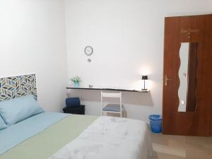 Schlafzimmer mit einem Bett und einem Schreibtisch an der Wand in der Unterkunft La luna nel Cortile in Serradifalco